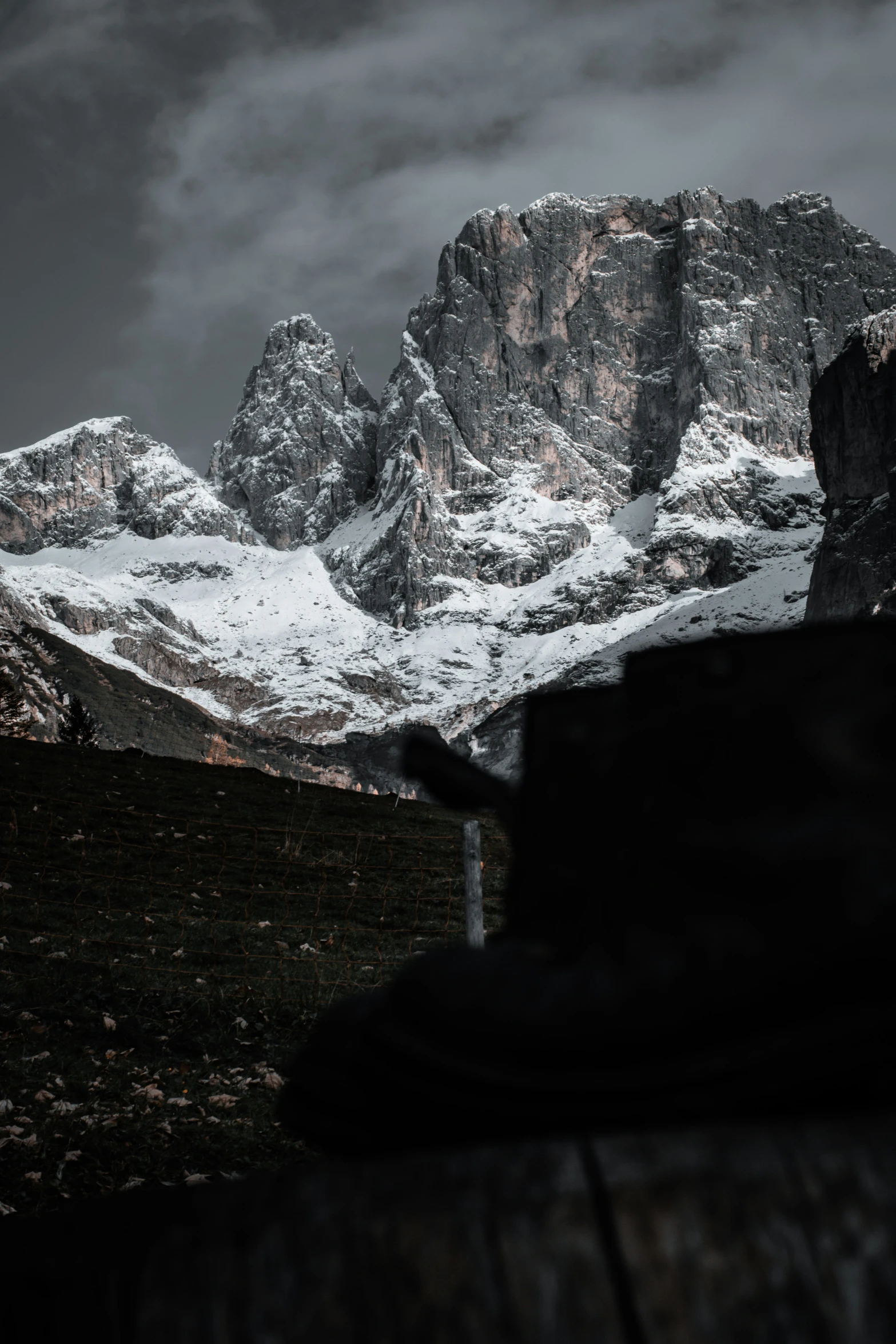 a bench with snow on it overlooking a mountain range