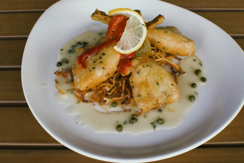 a white plate topped with fried chicken covered in sauce