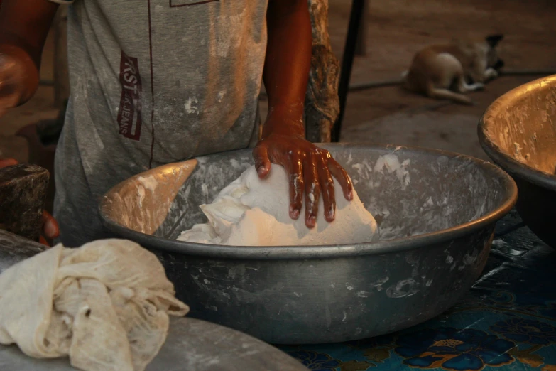 a person with his hands on a pan