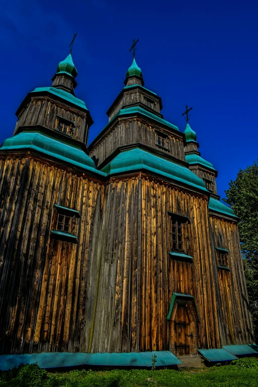 a building with a very long wooden wall next to a tree