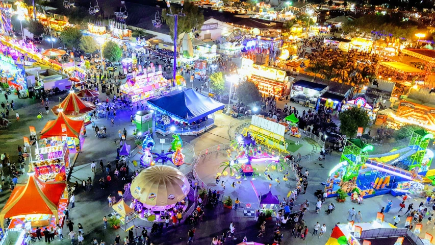 an aerial view of a carnival with illuminated rides and lights