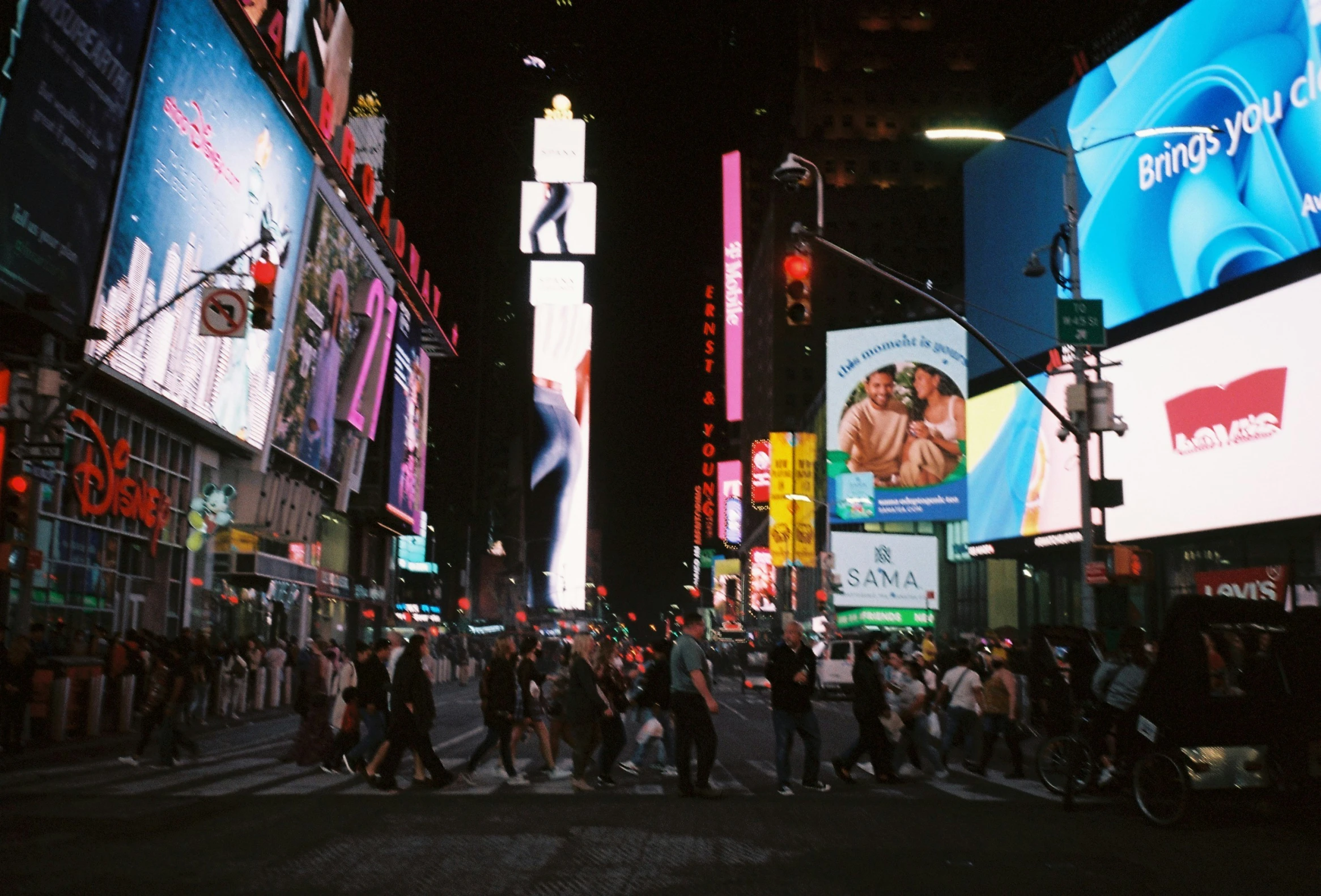 a crowd of people walking down the street in an urban area