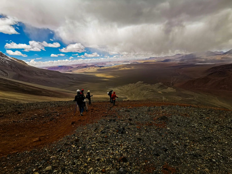 two people in hiking gear standing on a rocky mountain