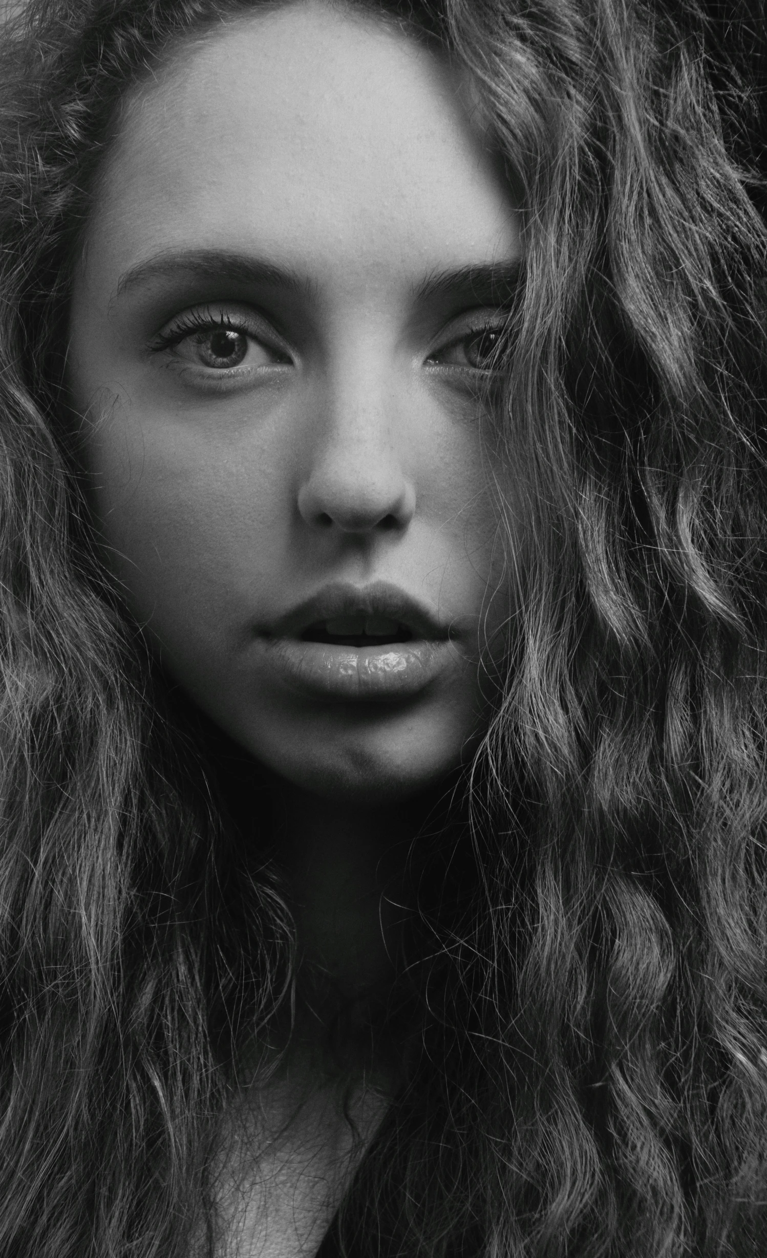 a woman with long curly hair in black and white