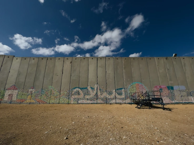 some graffiti on the side of a wall with blue sky