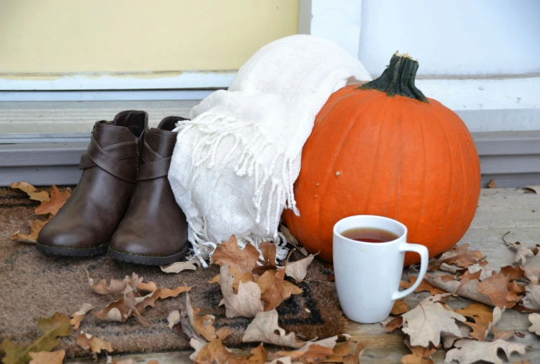 coffee cup, and a white and brown scarf on a porch