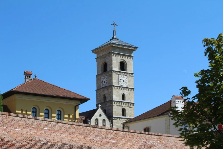 a stone building with a clock on it, next to a brick wall