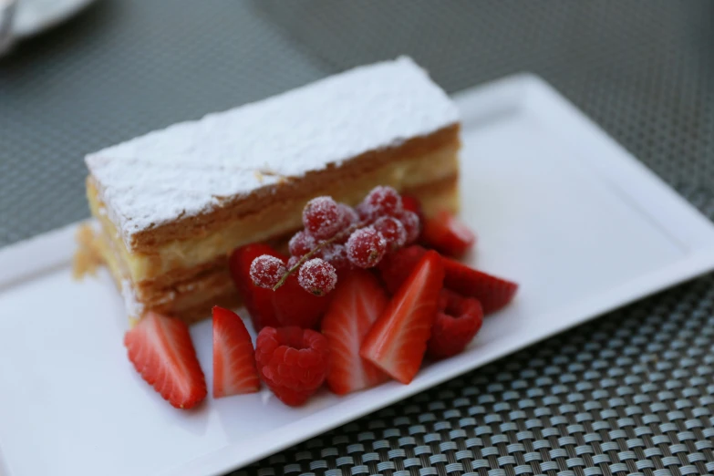a square piece of cake with strawberries on it