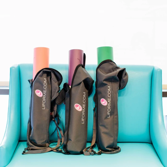 three yoga mats sitting on the back of an inflatable couch