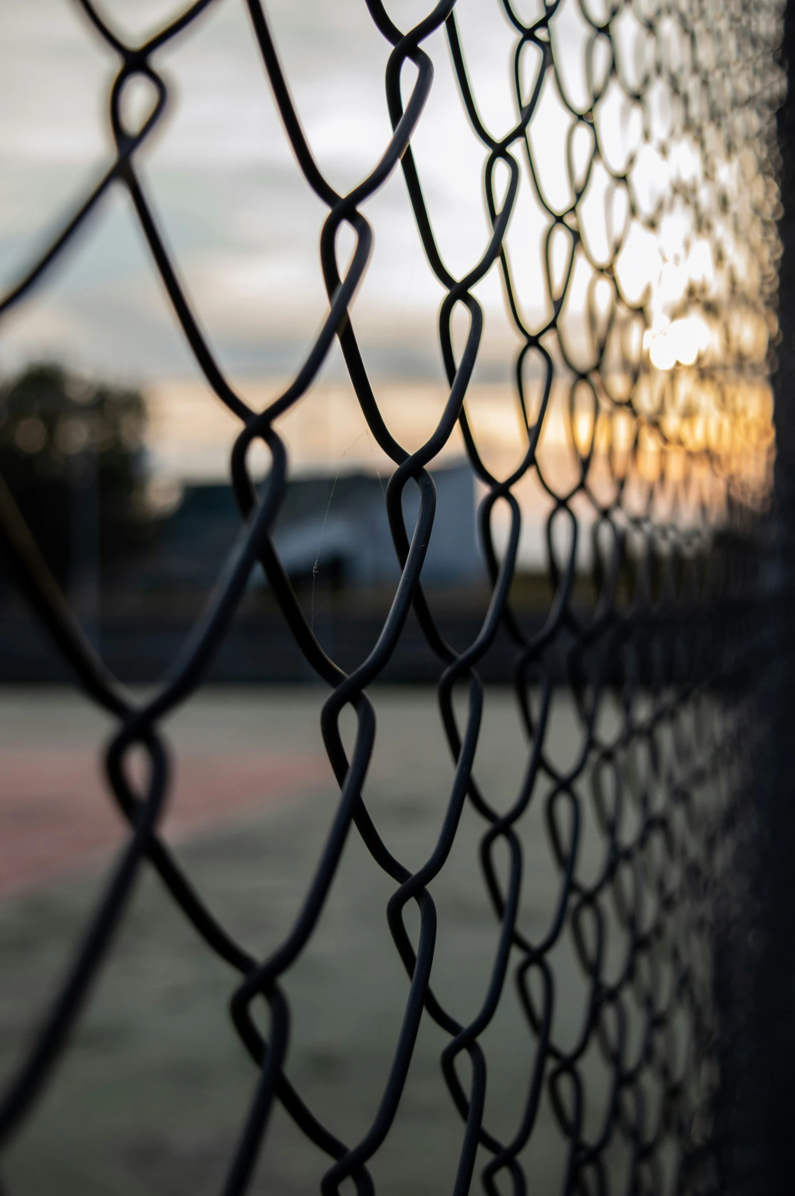 the silhouette of a fence and its chain link