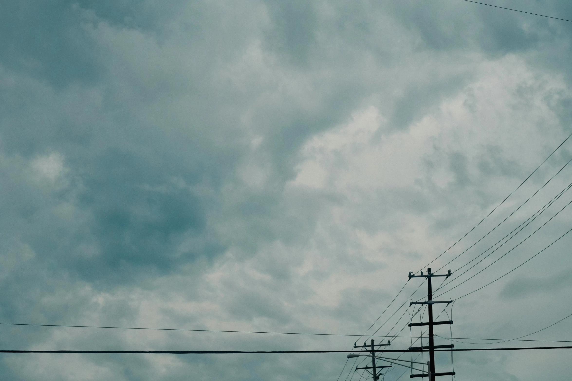 a stop light sitting on the side of the road near power lines