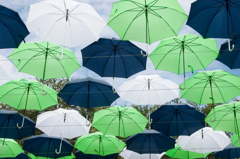 a group of green and white umbrellas against a blue sky