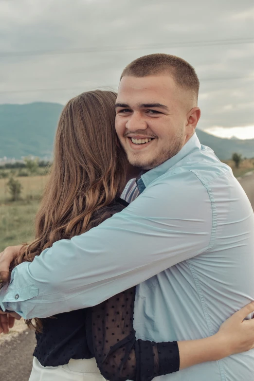 a smiling couple hugging and emcing each other