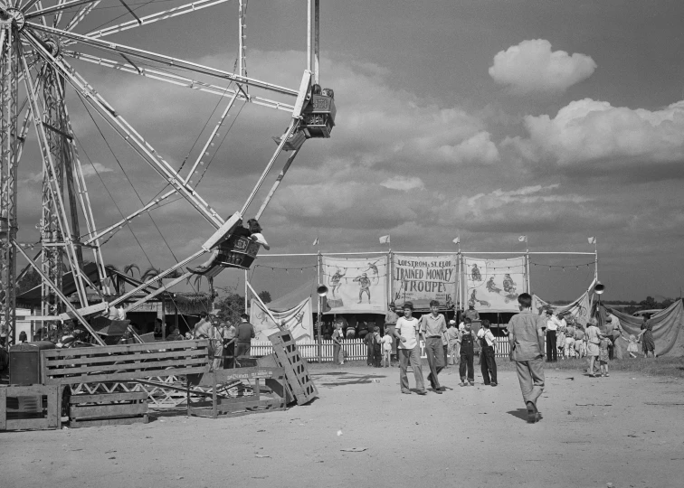 black and white po of people standing in front of an old ferris wheel