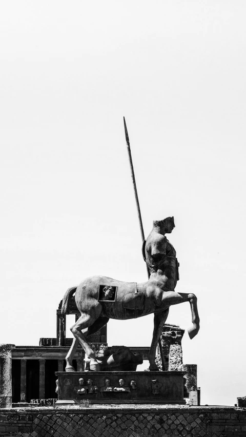 statue of an unknown man holding sword near building