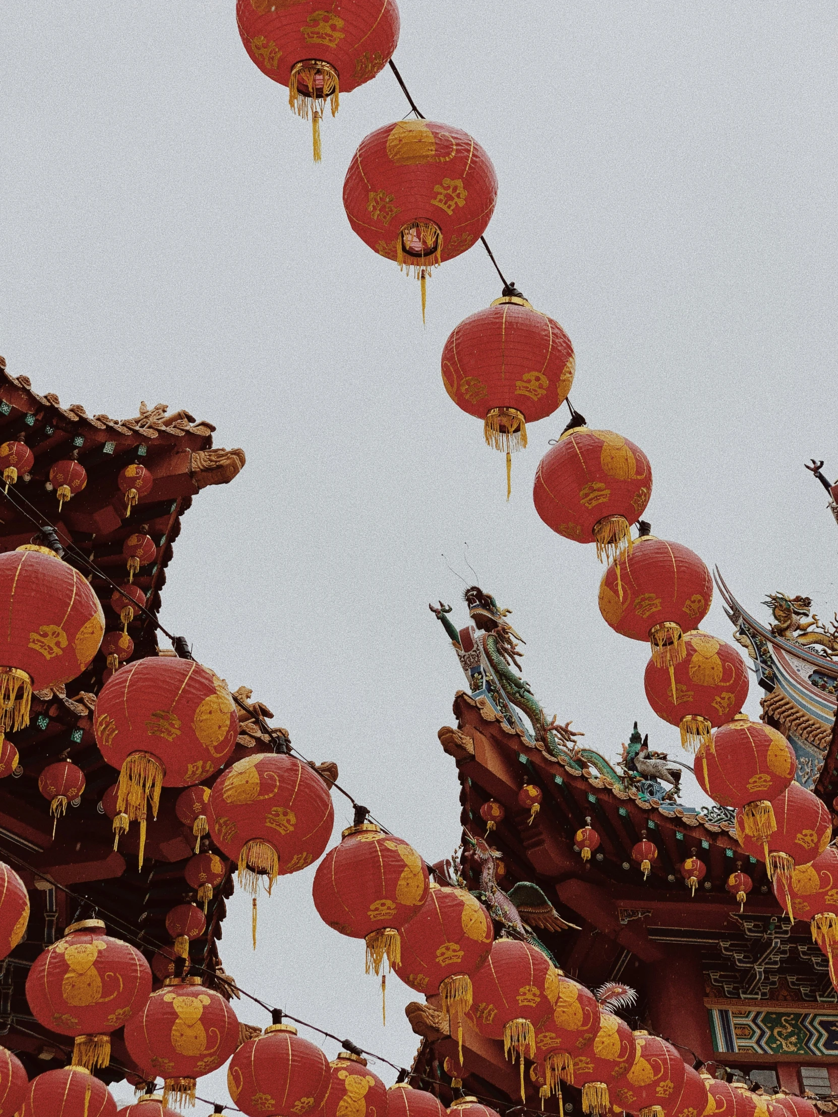 lanterns hanging from chinese pagodas with sky in background