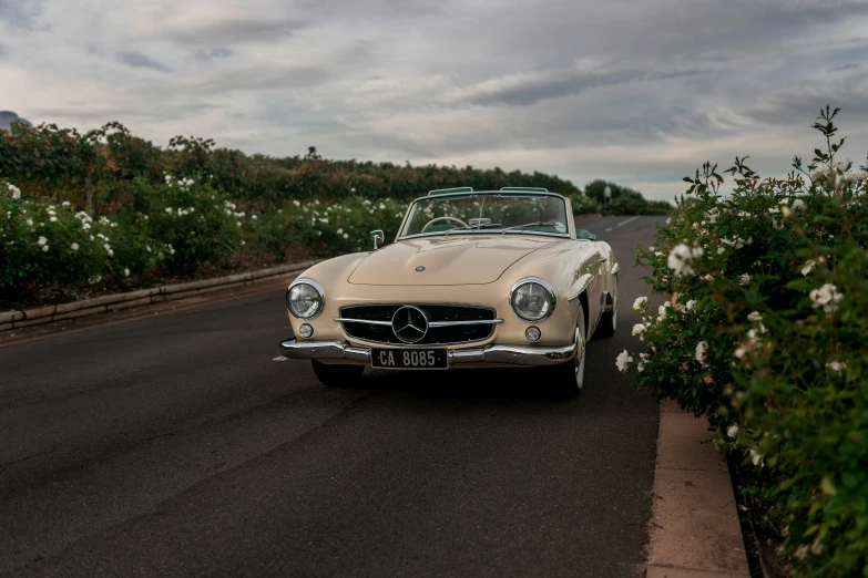 a vintage mercedes sits parked on the street