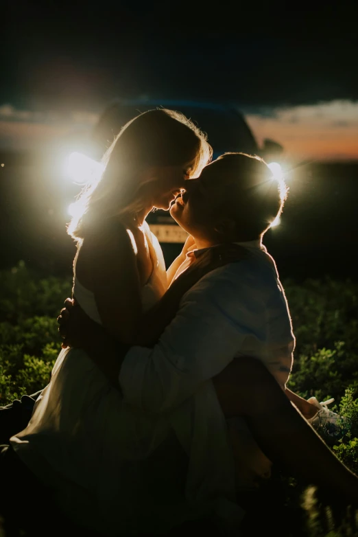 a man and woman kissing each other in the night