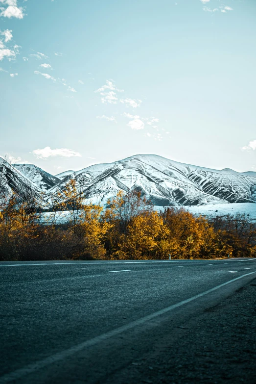 a long and narrow road with the mountains in the background