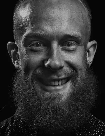 an old man with a bald head and a beard smiles
