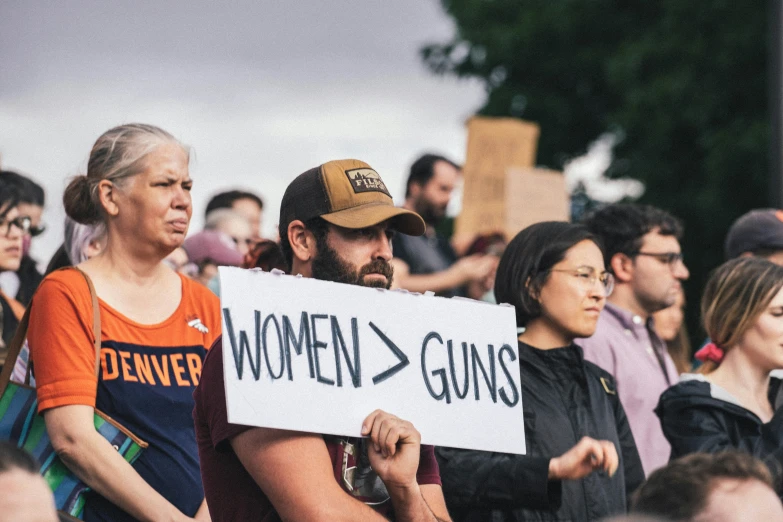 people are standing and holding signs that say women - guns