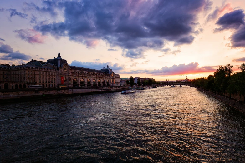 there is a sunset over a river that has the sky reflecting off it