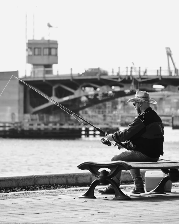 man sitting on a bench with fishing gear in his hands