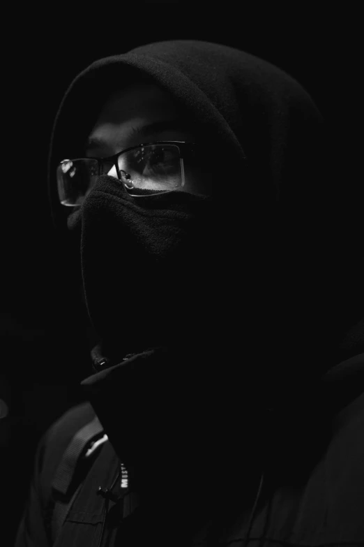 a hooded man wearing glasses and a hood