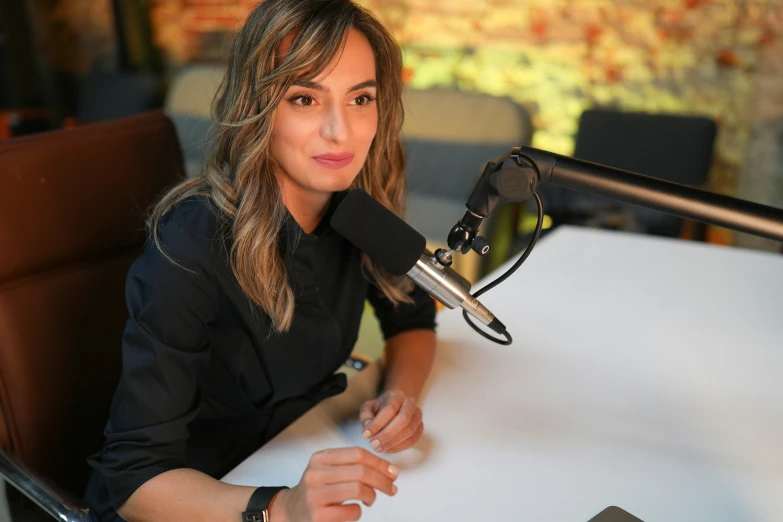 the woman is sitting at the table with a microphone in her hand