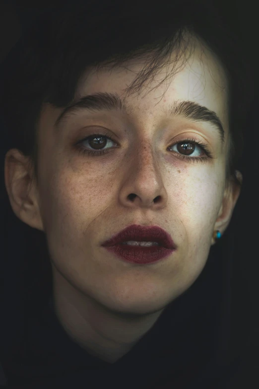 a close up view of a woman's face with freckled skin and blue eyes