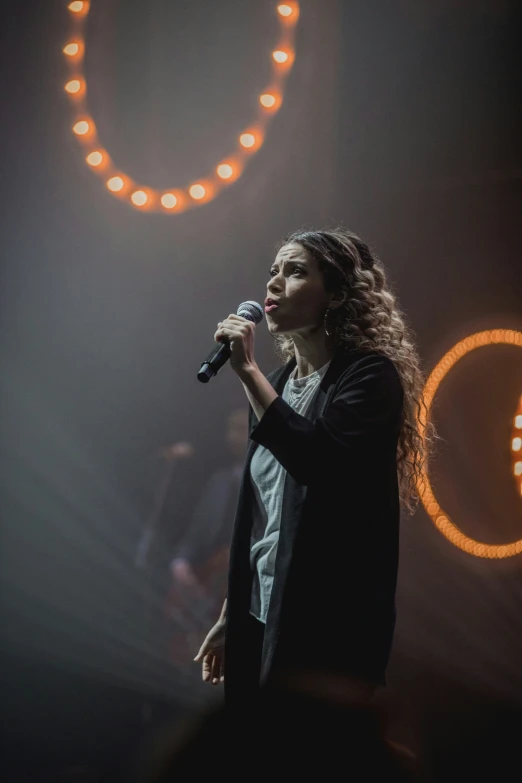 a woman standing up with a microphone in front of her