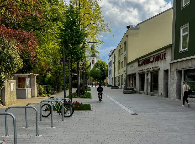 a city street scene with bicycles parked on the curb and pedestrian walking along the sidewalk