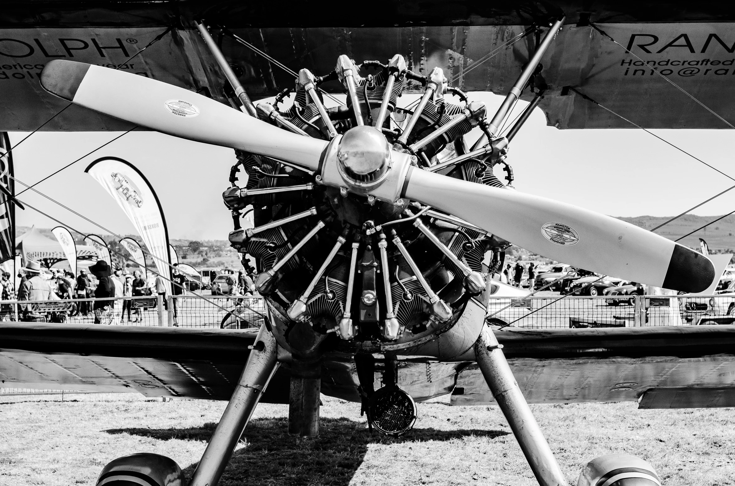 a propeller powered biplane parked on the grass at an air show