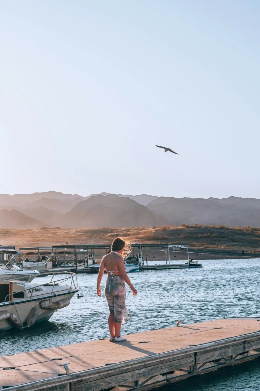 a man walking along side of a pier on water