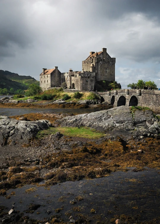 a castle built on top of a rock in front of some water