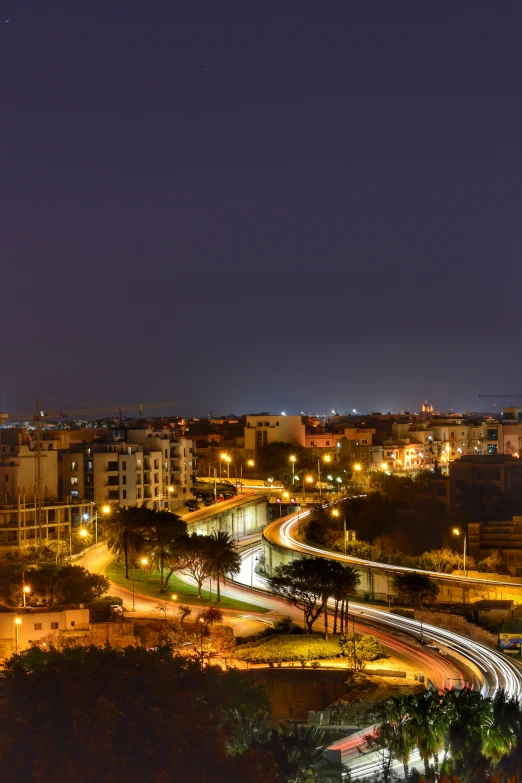 cityscape at night with lights from above and a street light overhead