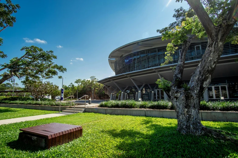 a bench sits in the grass outside of a building