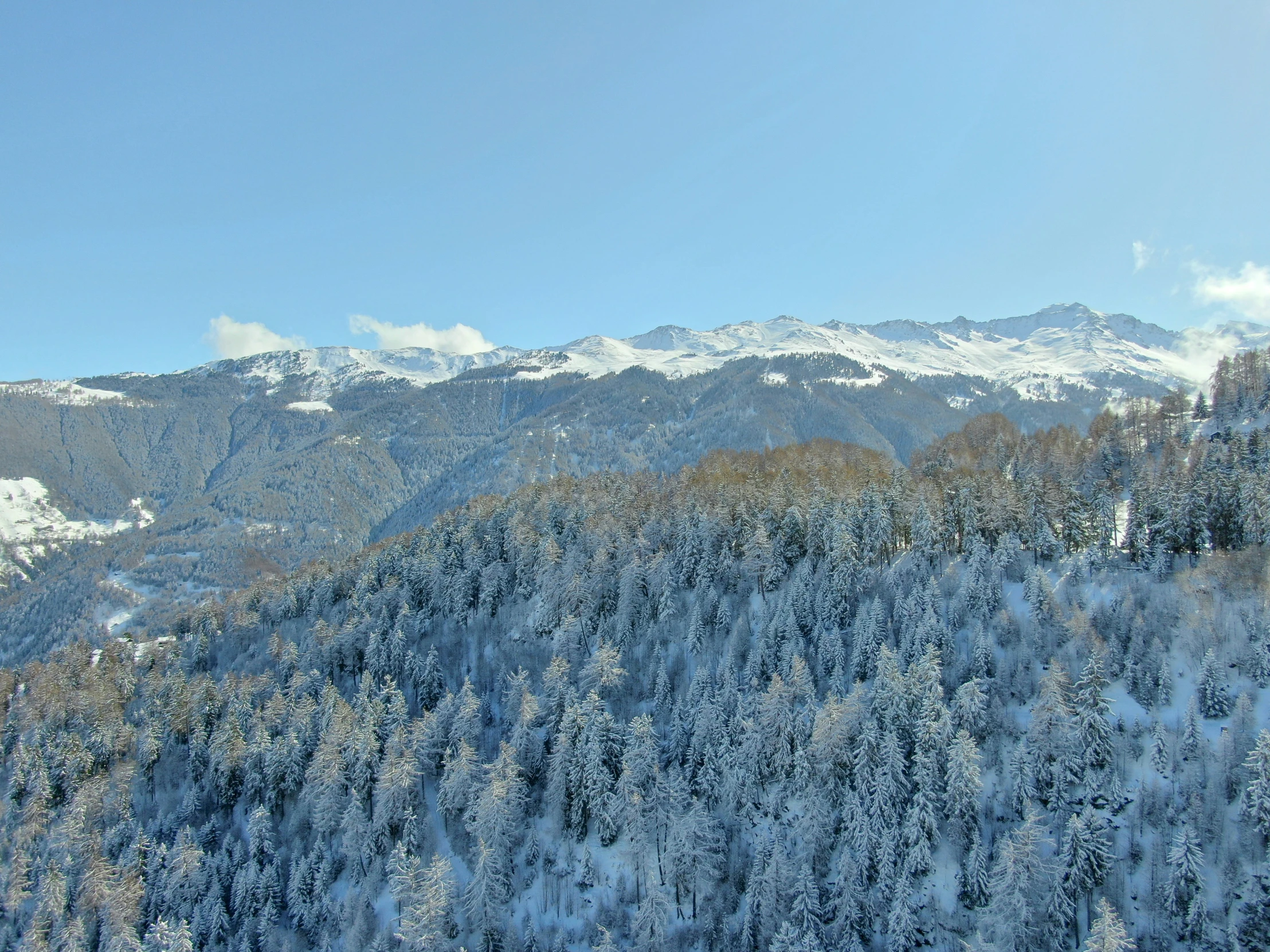 a snowy mountain range under a blue sky