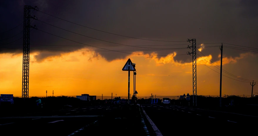 a train track with a yellow sky and some clouds