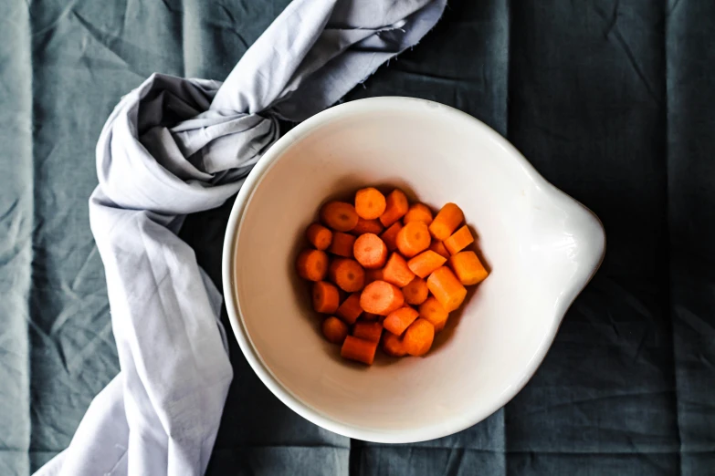 a bowl filled with chopped carrots and cloth