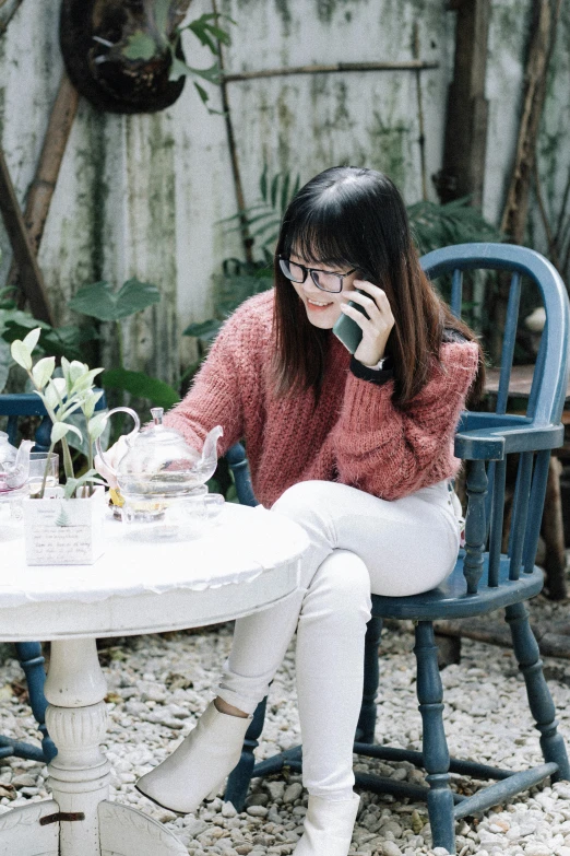 a woman talking on the phone while sitting in a chair