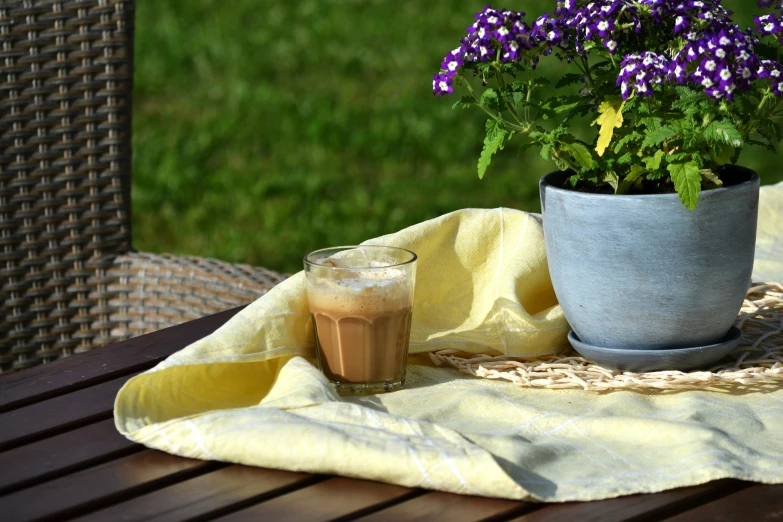 a table is sitting outside with some flowers in a pot