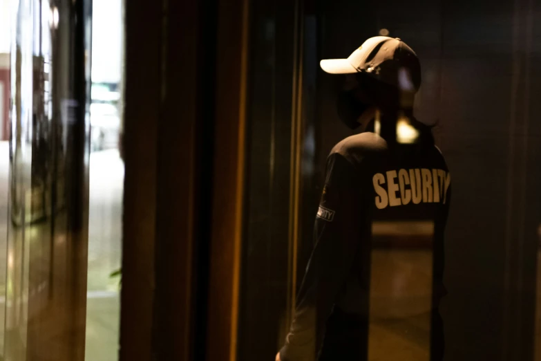 a security man is standing outside wearing a hat