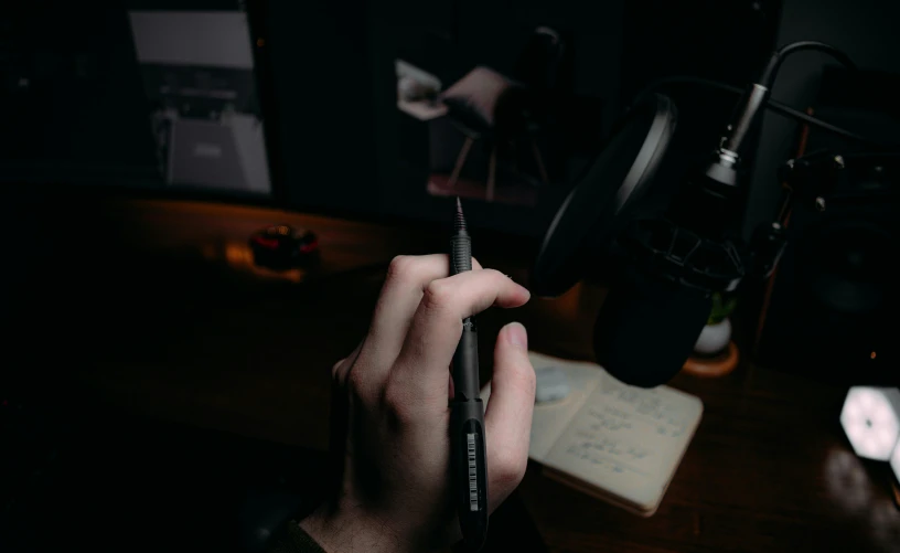 person holding a pen while writing on a piece of paper