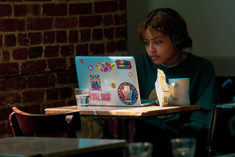 a young man sitting in front of a laptop computer