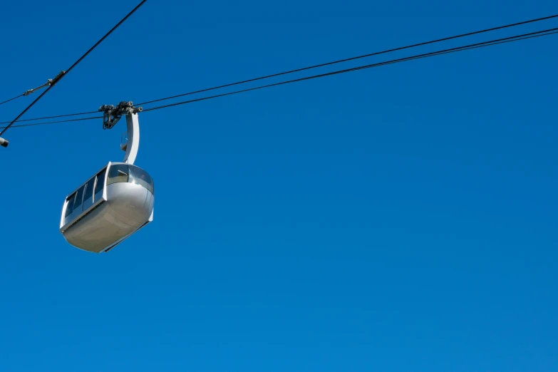 a cable car hanging on a clear blue sky