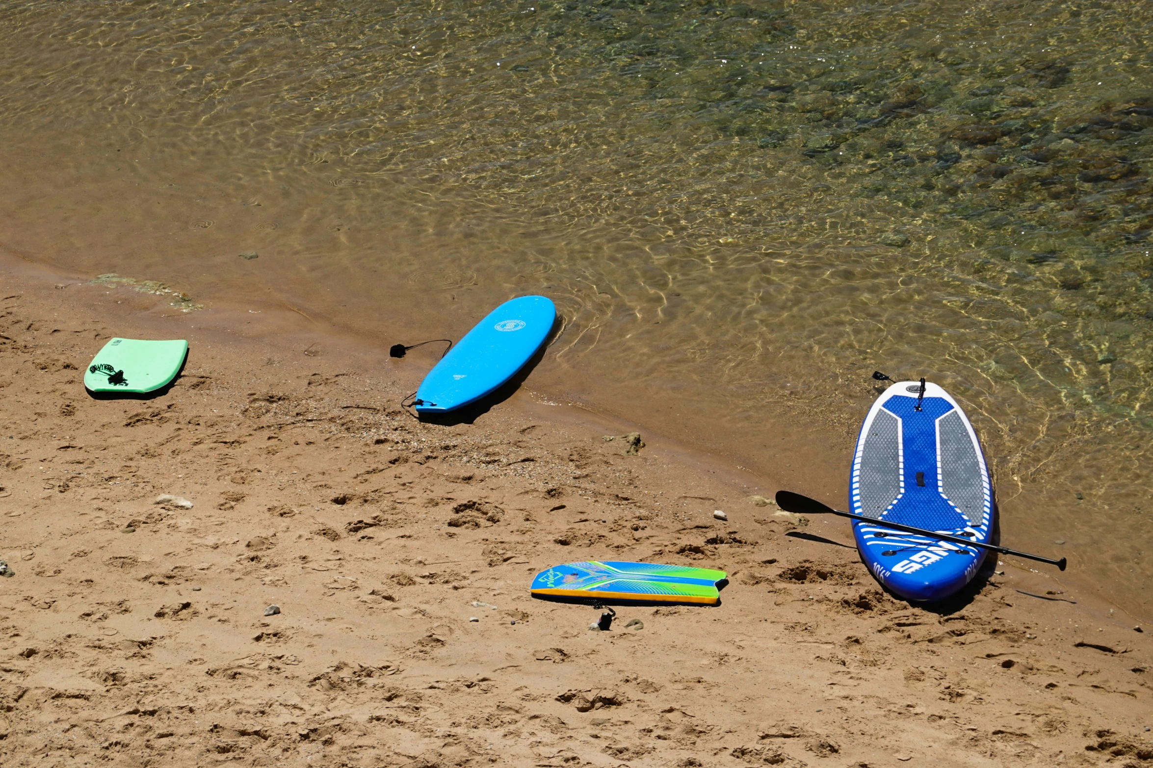 four different paddle boards sitting on top of a beach