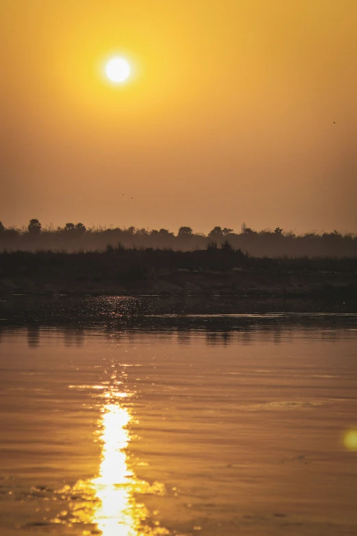 the sun sets over the horizon across the water