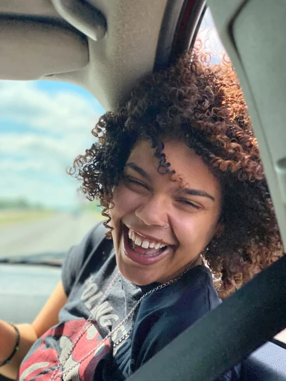 a woman smiling and inside of a car