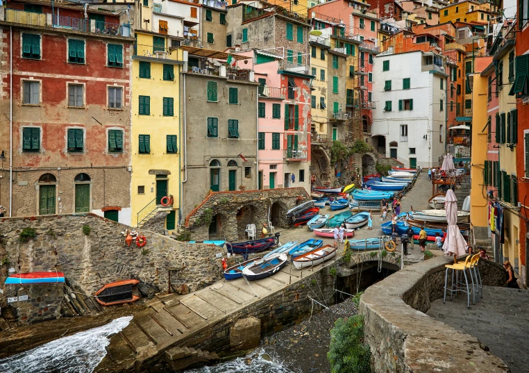 colorful buildings surround an old street as water pours